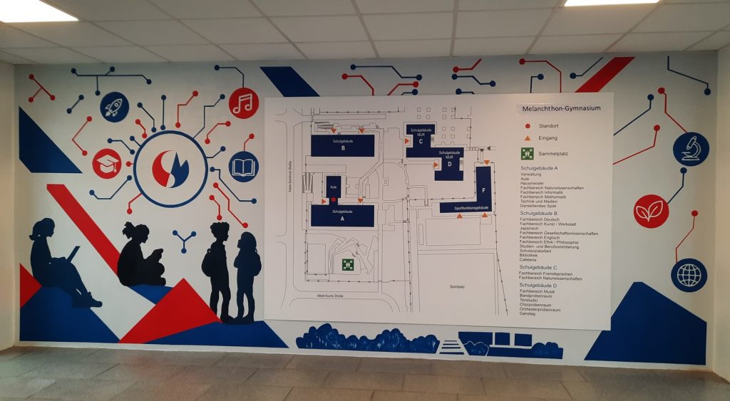 Eine Wand mit Lageplan der Schule. Die Wand ist mit dem im Text beschriebenen Muster bemalt.